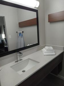 a bathroom with a sink and a large mirror at RELAX INN in Rockingham