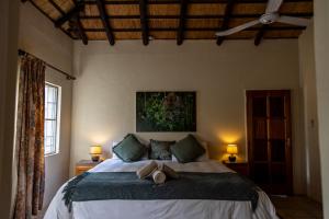 - une chambre avec un lit avec deux chapeaux dans l'établissement Tamanini Timbavati Lodge, à Hoedspruit