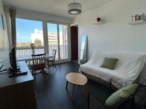 a living room with a bed and a table with chairs at T2 au coeur de Saint-Brieuc in Saint-Brieuc