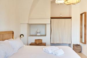 a bedroom with a white bed with towels on it at Il Trappetello in Monopoli