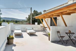 a patio with chairs and tables on a white wall at Il Trappetello in Monopoli