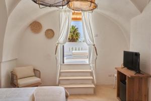 a room with a staircase with a tv and a chair at Il Trappetello in Monopoli