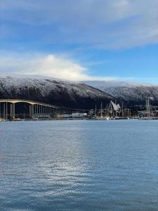 a large body of water with a building in the background at Cozy apartment with a view in Tromsø