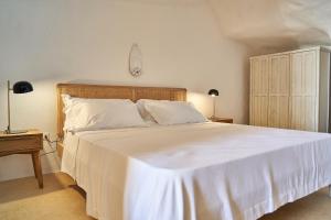 a bedroom with a large white bed with two lamps at Il Trappetello in Monopoli