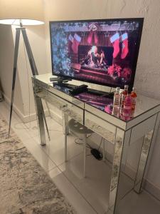 TV en un escritorio de cristal con chimenea en Cwtch Cardiff Bay, en Cardiff