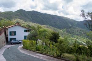 een huis en een auto op een weg met bergen bij Bed&Breakfast Bella Vita in Bracco
