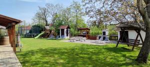 a park with a playground with a slide at Trinity Vendégház Abádszalók in Abádszalók
