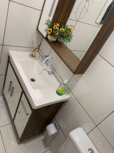 uma casa de banho com um lavatório, um espelho e um WC. em Casa com Piscina em Região Nobre de Cascavel em Cascavel