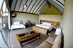 um quarto amplo com 2 camas e um sofá em HOTEL RUSTICA TARAPOTO em Tarapoto