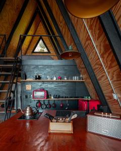 a kitchen in a cabin with a wooden ceiling at NOMADPLACE in São Bento do Sapucaí