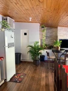 a room with a refrigerator and a table with plants at Casa com Piscina em Região Nobre de Cascavel in Cascavel