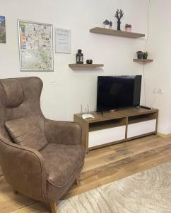 a living room with a chair and a television at Nesi apartmenti in Pristina
