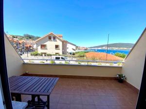 a balcony with a table and a view of the ocean at Apartamento Playa Blanca in Corcubión