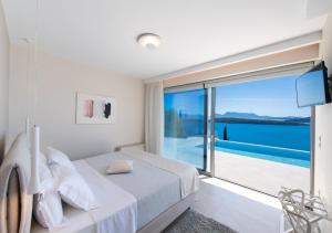 a bedroom with a bed and a view of the ocean at Apaggio Villas in Nydri