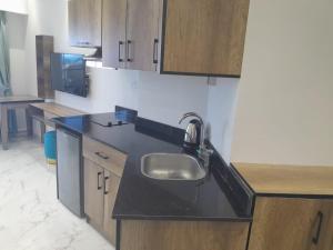 a kitchen with a sink and wooden cabinets at Juliana Beach Hurghada in Hurghada