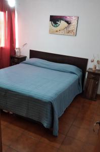 1 dormitorio con 1 cama con manta azul en Hospedaje Isabelina en Las Heras