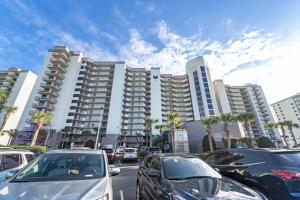 un parking avec des voitures garées devant un grand bâtiment dans l'établissement Phoenix Vi 1210, à Orange Beach