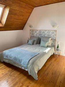 1 dormitorio con 1 cama grande y suelo de madera en La Teyssière, en Bar-sur-Seine