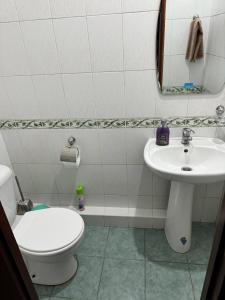a bathroom with a white toilet and a sink at Your sweet home in Tashkent in Tashkent