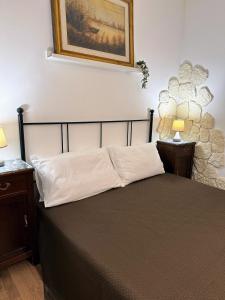 a bedroom with a bed with a picture on the wall at Sweet Lotus Apartment in Taormina
