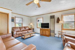 a living room with leather furniture and a flat screen tv at Waterfront Family Cottage on Lake Champlain in Swanton