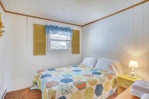 a bedroom with a quilt on a bed and a window at Waterfront Family Cottage on Lake Champlain in Swanton