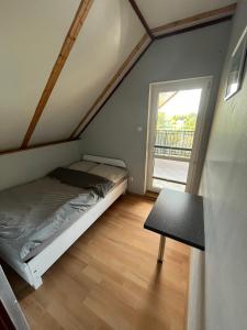 a small bedroom with a bed and a table at Dom i domek nad morzem i jeziorem - Jezierzany - blisko Jarosławiec in Jezierzany