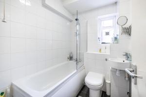 a white bathroom with a toilet and a sink at Modern Rooms in Zone 2 London, Finsbury Park in London