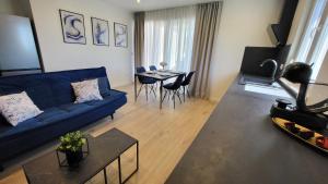 a living room with a blue couch and a table at Apartments Amare in Kali