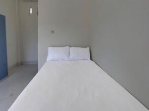 ein großes weißes Bett in einem weißen Zimmer in der Unterkunft OYO Life 92769 Janigo Kos in Tanjungkarang