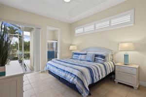 a bedroom with a bed and a balcony at Cape Serenity- Luxury Waterfront Villa with Kayaks in Cape Coral