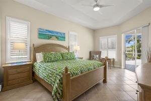 a bedroom with a bed with a green bedspread at Cape Serenity- Luxury Waterfront Villa with Kayaks in Cape Coral