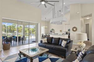 a living room with a couch and a table at Cape Serenity- Premier Waterfront Villa with Kayaks and Bikes in Cape Coral