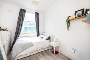 a white bedroom with a bed and a window at Modern Rooms in Zone 2 London, Finsbury Park in London