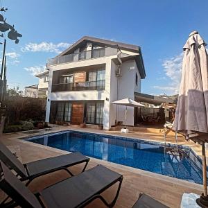 a house with a swimming pool in front of a house at villa nerit in Fethiye