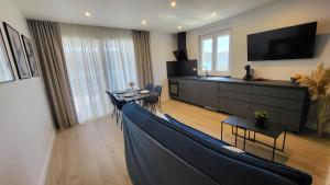 a living room with a blue couch and a tv at Apartments Amare in Kali