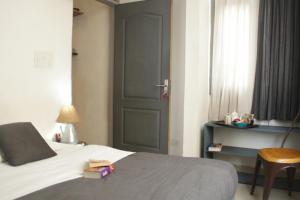 1 dormitorio con cama, puerta y silla en Bed & Chai Guesthouse en Nueva Delhi