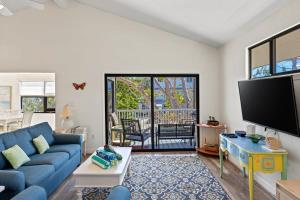 a living room with a blue couch and a tv at Captiva Beach Bungalow on Turner Beach in Captiva