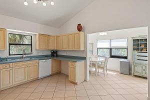 a large kitchen with wooden cabinets and a table at Captiva Beach Bungalow on Turner Beach in Captiva