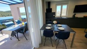 a dining table and chairs in a room with a view at Apartments Amare in Kali