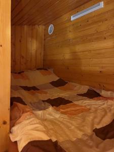 1 dormitorio con 1 cama en una cabaña de madera en AGROTURYSTYKA WIOSNA en Wiosna