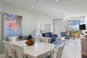 サニベルにあるExquisite Beachfront Residence at Shell Island Beach Club of Sanibelの白いテーブルと椅子のあるリビングルーム