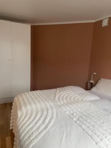 a white bed in a bedroom with a wall at Cozy apartment with a view in Tromsø