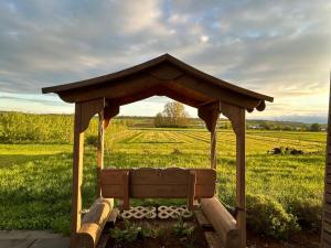a wooden bench in a field with a gazebo at Schlaffässer auf dem Krügele Hof in Murr