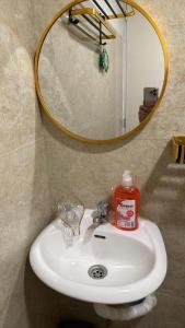 a bathroom sink with a mirror and a bottle of soap at Windmill Chimes in Rizal +31 photos