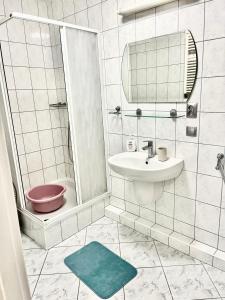 uma casa de banho com um lavatório, um chuveiro e um WC. em Przytulny apartament em Augustów