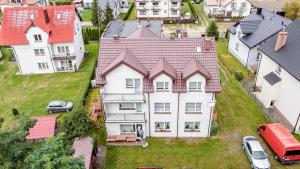 an aerial view of a large white house with red roofs at Pokoje i Apartamenty Marek - Niedaleko Plaży in Ostrowo