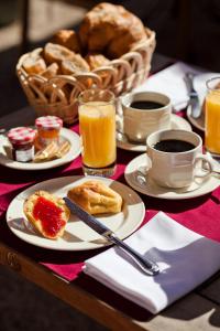 einen Tisch mit Tellern und Tassen Kaffee und Brot in der Unterkunft Hotel Belle Epoque in Beaune