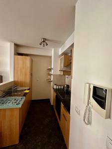 una pequeña cocina con fregadero y microondas en City center apartment with balcony en Budapest