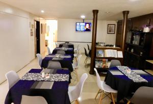um quarto com várias mesas e cadeiras e uma televisão em Hotel Casa Navi em Bogotá